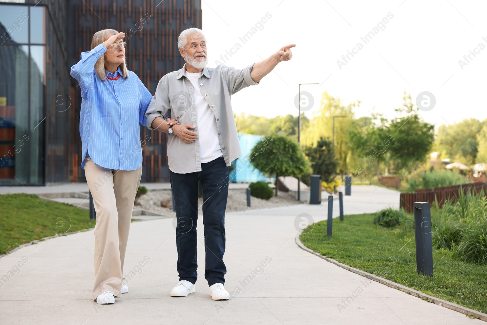 Lovely senior couple walking together in park, space for text Photo of Lovely senior couple walking together in park, space for text
