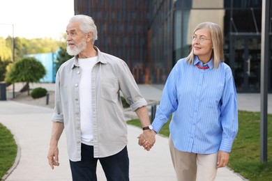 Photo of Lovely senior couple walking together in park