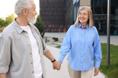 Photo of Lovely senior couple walking together in park
