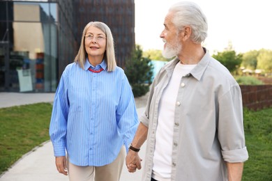 Photo of Lovely senior couple walking together in park