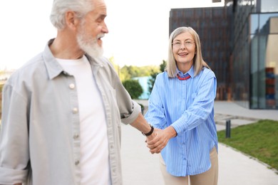 Photo of Lovely senior couple walking together in park