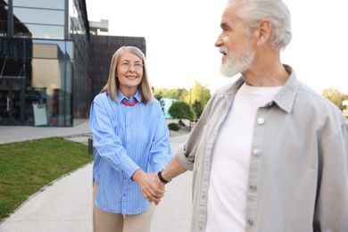 Photo of Lovely senior couple walking together in park