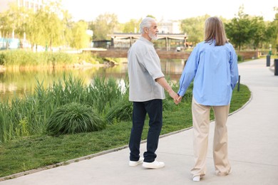 Photo of Lovely senior couple walking together in park