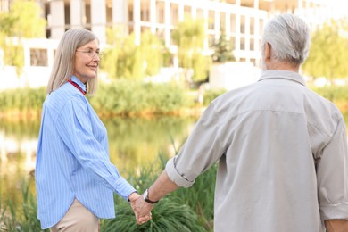 Photo of Lovely senior couple walking together in park
