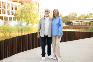 Photo of Lovely senior couple walking together in park