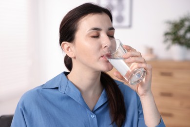 Photo of Woman drinking water from glass at home