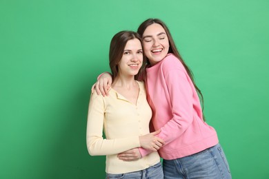 Photo of Happy friends hugging each other on green background