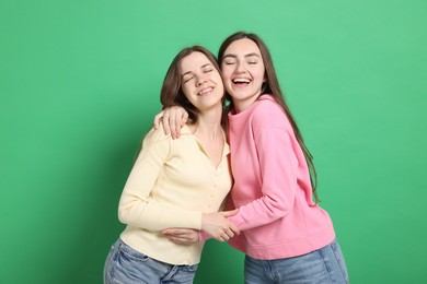 Photo of Happy friends hugging each other on green background