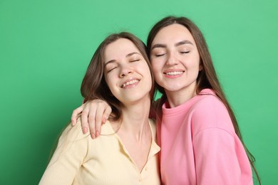 Photo of Happy friends hugging each other on green background