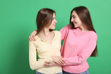 Photo of Happy friends hugging each other on green background