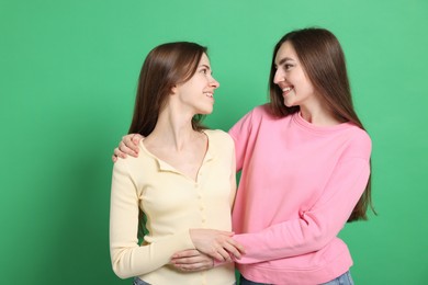 Photo of Happy friends hugging each other on green background