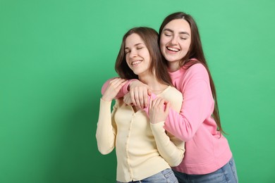 Photo of Friends hugging each other on green background, space for text