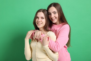 Photo of Friends hugging each other on green background