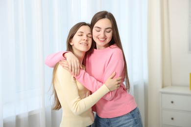 Photo of Happy friends hugging each other at home
