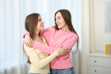 Photo of Happy friends hugging each other at home