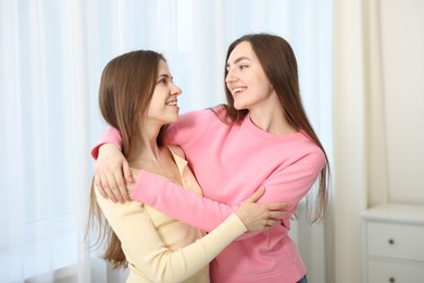 Photo of Happy friends hugging each other at home