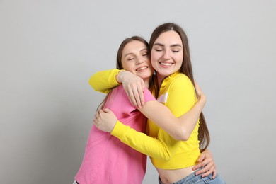 Photo of Friends hugging each other on light grey background