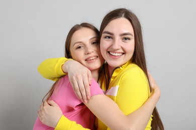 Photo of Friends hugging each other on light grey background