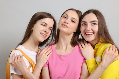 Photo of Friends hugging each other on light grey background