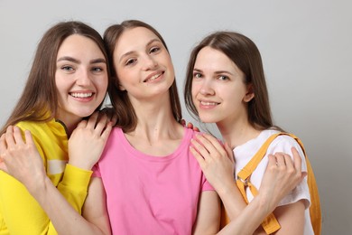 Photo of Friends hugging each other on light grey background