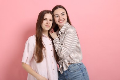Photo of Friends hugging each other on pink background