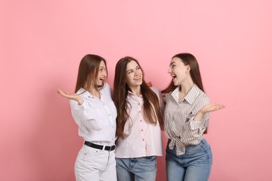 Photo of Friends hugging each other on pink background