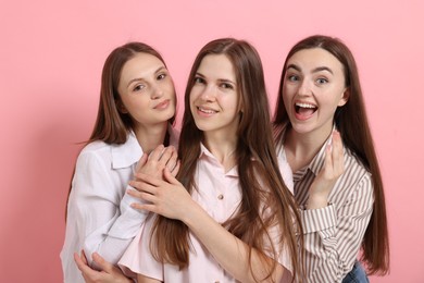 Photo of Friends hugging each other on pink background