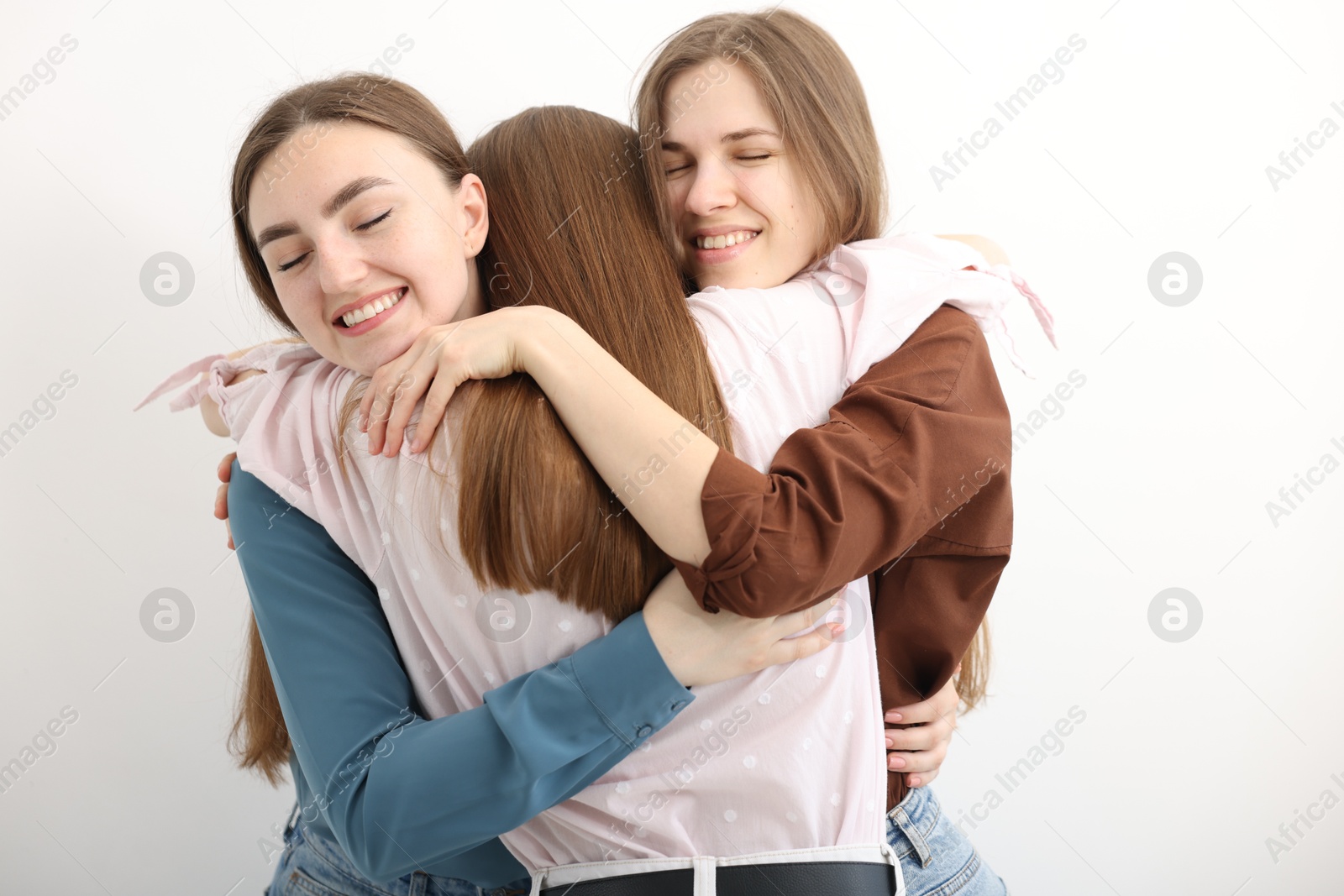Friends hugging each other on white background Photo of Friends hugging each other on white background
