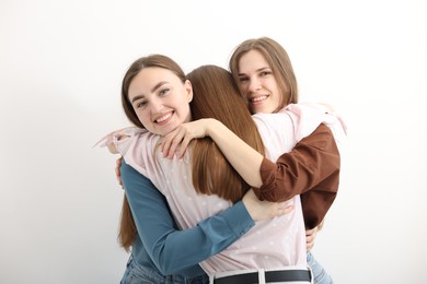 Photo of Friends hugging each other on white background