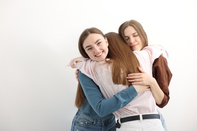 Photo of Friends hugging each other on white background, space for text