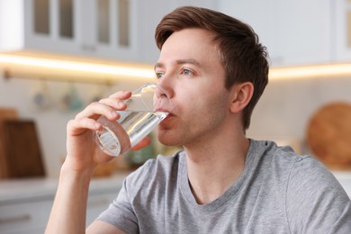 Photo of Man drinking water from glass in kitchen