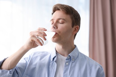 Photo of Man drinking water from glass at home
