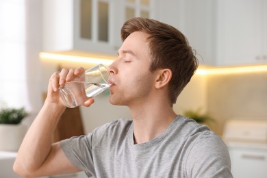 Photo of Man drinking water from glass in kitchen