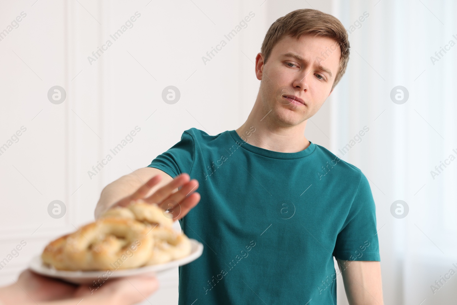 Gluten free diet. Man refusing from pastries indoors, selective focus Photo of Gluten free diet. Man refusing from pastries indoors, selective focus