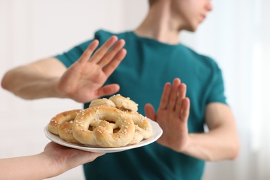 Photo of Gluten free diet. Man refusing from pastries indoors, selective focus