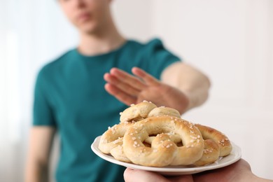 Photo of Gluten free diet. Man refusing from pastries indoors, selective focus