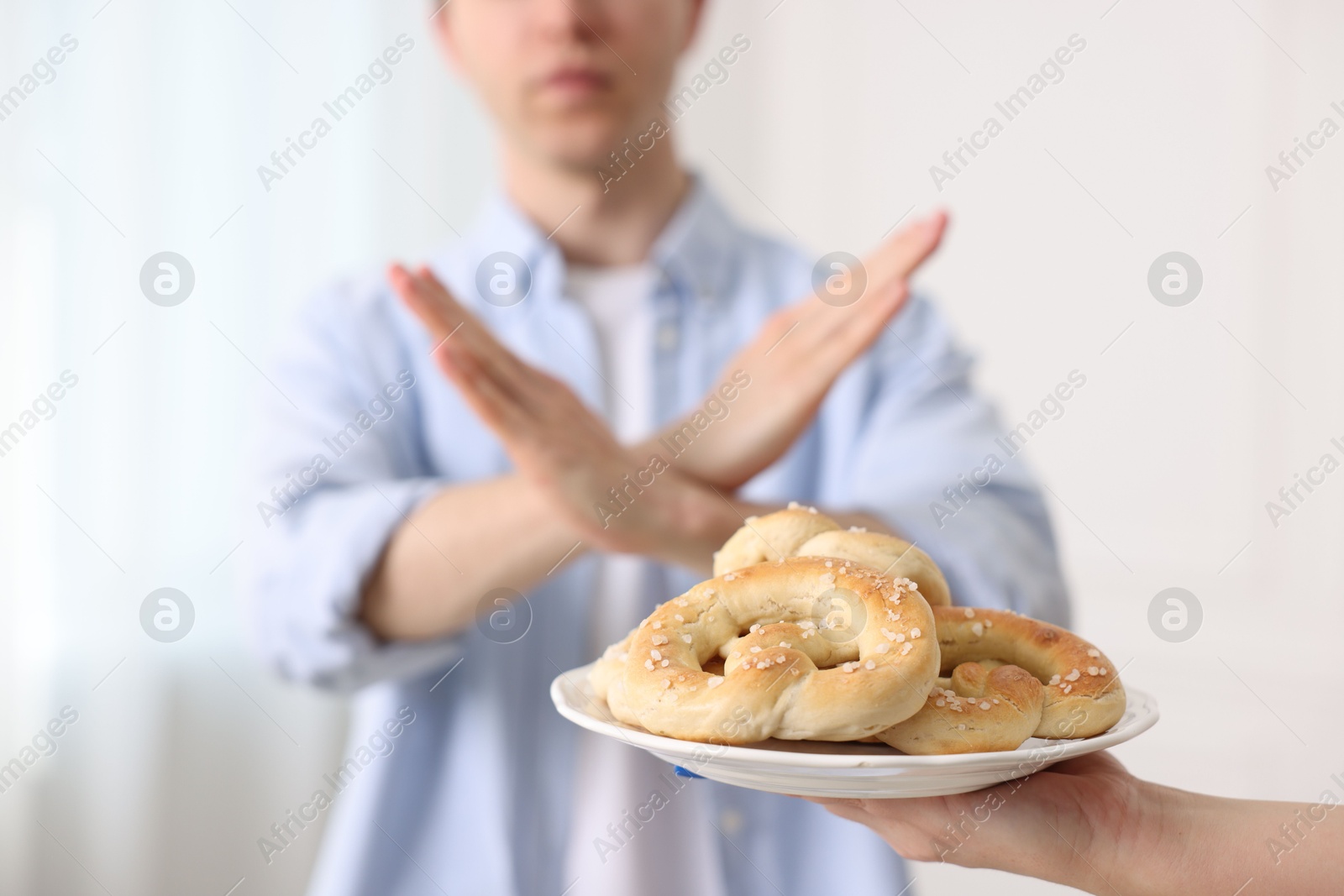 Gluten free diet. Man refusing from pastries indoors, selective focus Photo of Gluten free diet. Man refusing from pastries indoors, selective focus