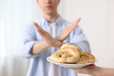 Photo of Gluten free diet. Man refusing from pastries indoors, selective focus