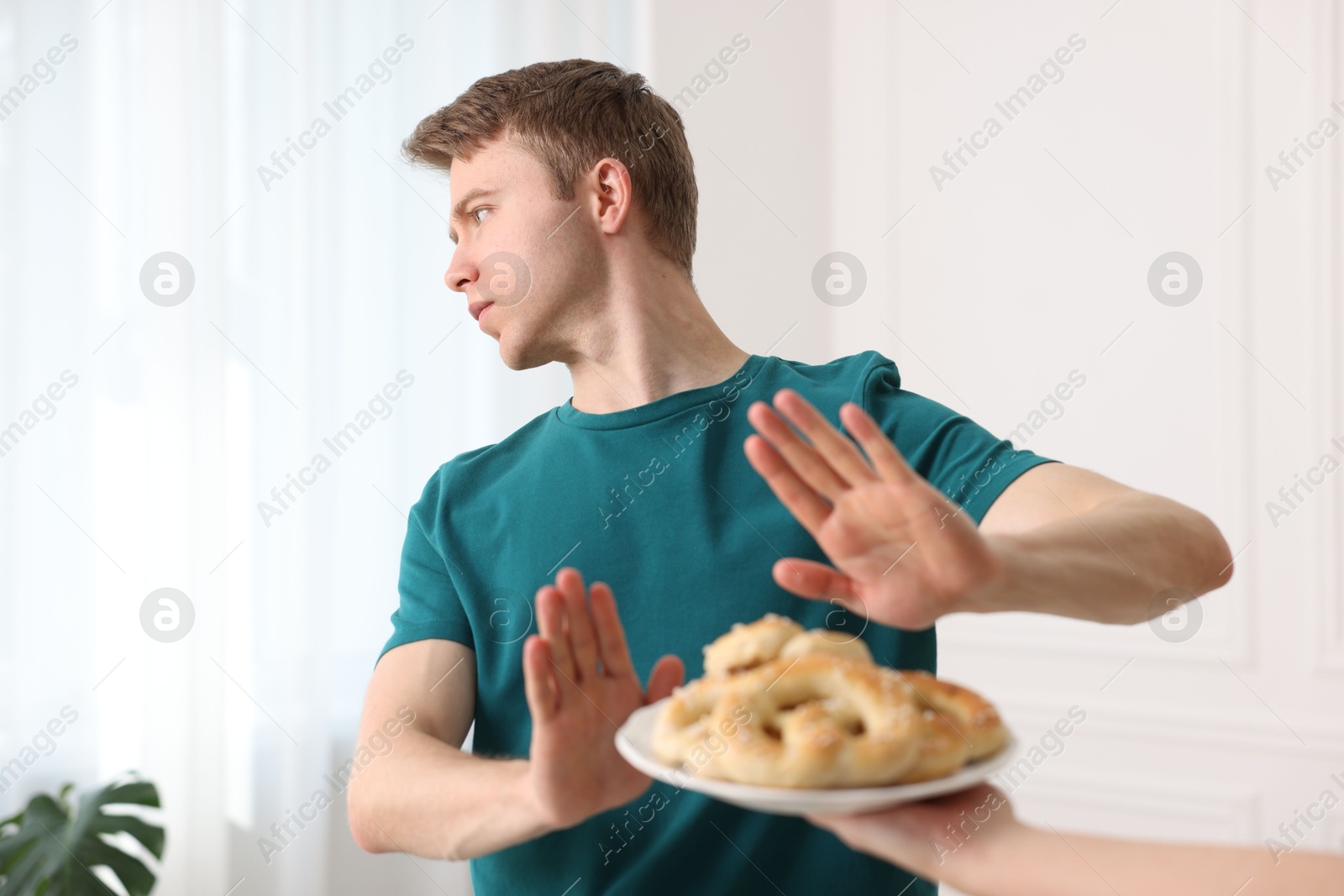 Gluten free diet. Man refusing from pastries indoors, selective focus Photo of Gluten free diet. Man refusing from pastries indoors, selective focus