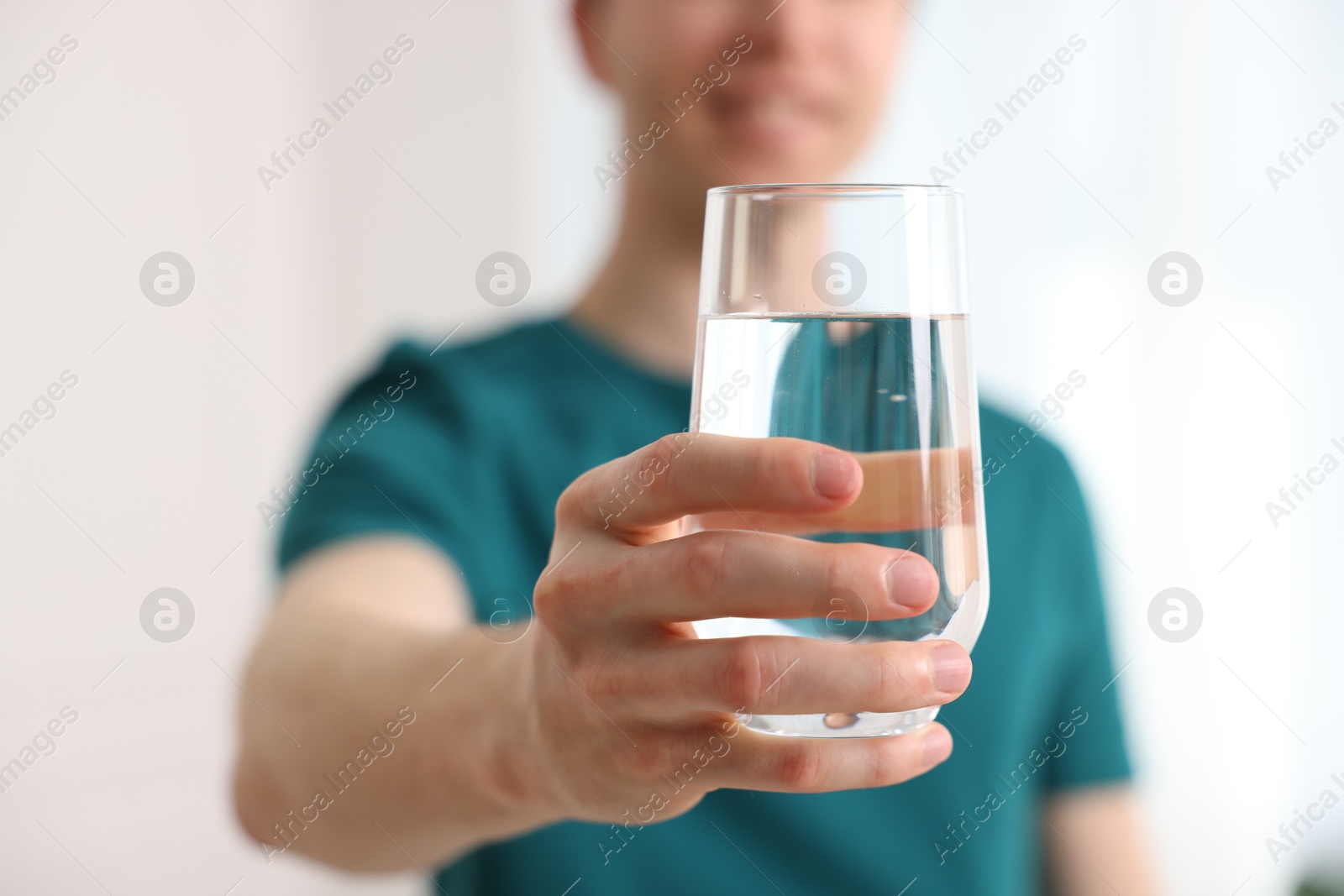 Man with glass of water at home, selective focus Photo of Man with glass of water at home, selective focus