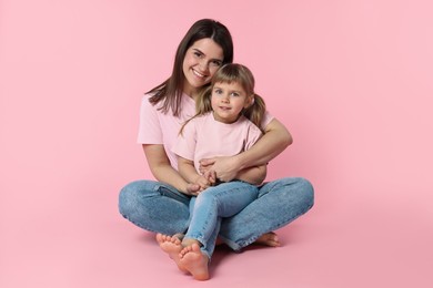 Photo of Happy mother and her cute daughter on pink background