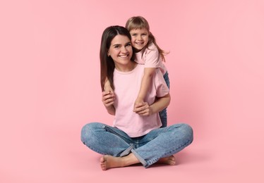 Photo of Happy mother and her cute daughter on pink background