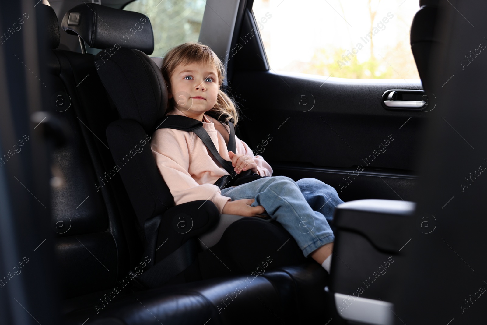 Little girl sitting in child safety seat inside car Photo of Little girl sitting in child safety seat inside car