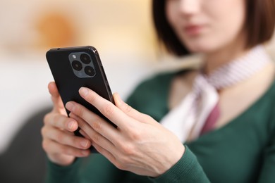 Photo of Woman using modern smartphone on sofa at home, closeup