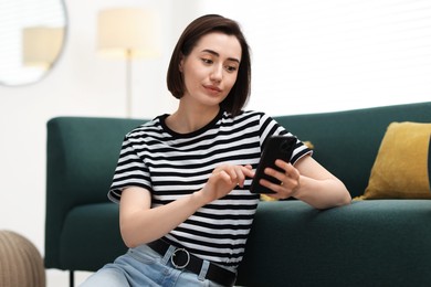 Photo of Beautiful woman using modern smartphone at home