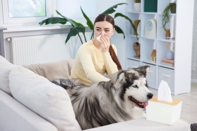 Photo of Woman suffering from allergy with her dog at home