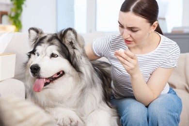 Photo of Woman suffering from allergy with her dog at home