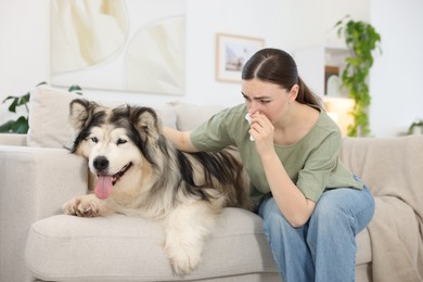 Photo of Woman suffering from allergy with her dog at home