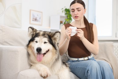Photo of Woman suffering from allergy with her dog at home