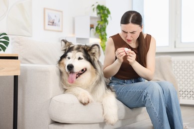 Photo of Woman suffering from allergy with her dog at home